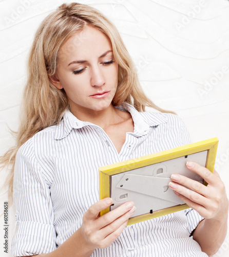 Photo: Woman looking at a frame with photos Woman looking at a frame with photos