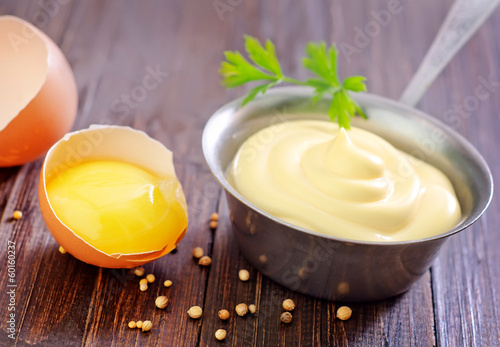 Photo: mayonnaise in metal spoon on wooden board mayonnaise in metal spoon on wooden board