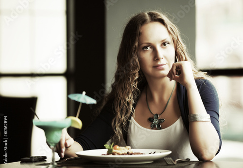 Photo: Beautiful young woman dining at restaurant Beautiful young woman dining at restaurant