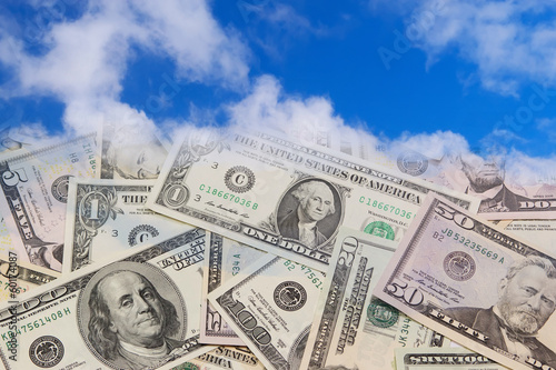 Photo: U.S. banknotes falling from the blue sky. U.S. banknotes falling from the blue sky.