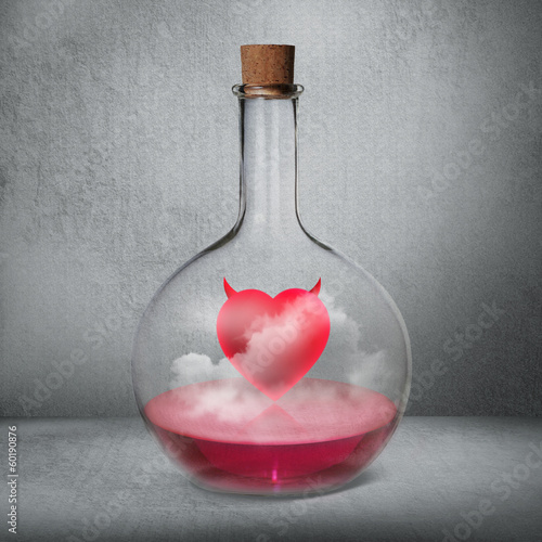 Photo: Glass bottle with philtre and love potion standing inside gray b Glass bottle with philtre and love potion standing inside gray b