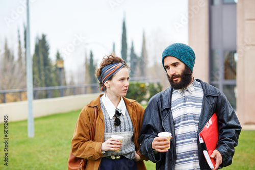 Photo: Hipster couple talking and drinking coffee to go Hipster couple talking and drinking coffee to go