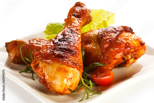 Photo: Grilled chicken legs and vegetables on white background Grilled chicken legs and vegetables on white background