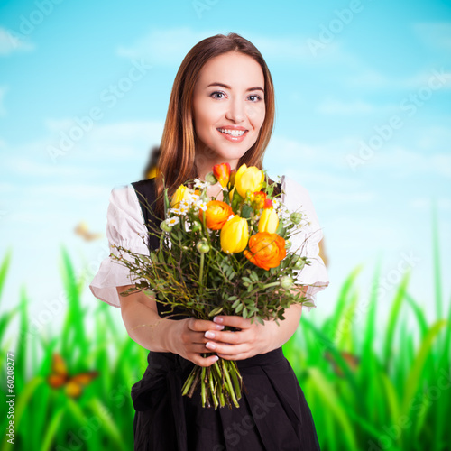 Photo: junge Frau im Dirndl mit Blumenstrauß junge Frau im Dirndl mit Blumenstrauß