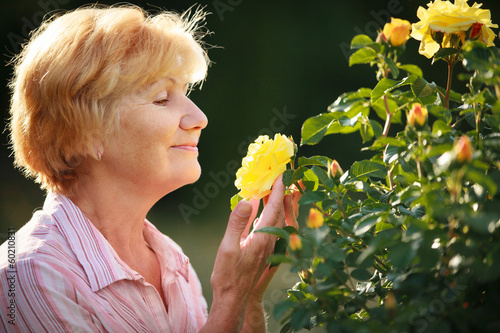 Photo: Expression. Senior Woman Model with Garden Roses. Springtime Expression. Senior Woman Model with Garden Roses. Springtime