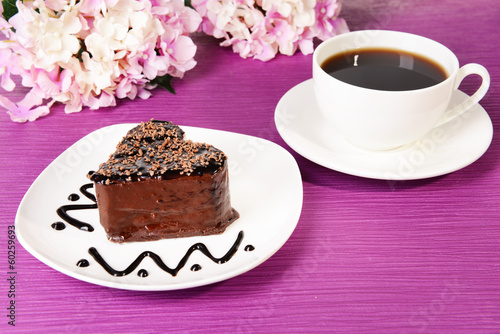 Photo: Sweet cake with chocolate on plate on table close-up Sweet cake with chocolate on plate on table close-up