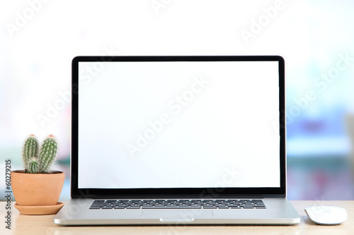 Photo: Laptop and cactus in flowerpot on wooden table Laptop and cactus in flowerpot on wooden table