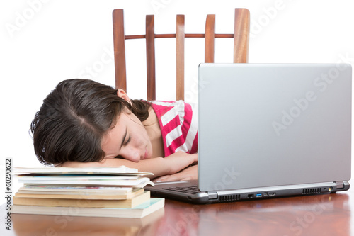 Photo: Tired teen student sleeping on her desk isolated on white Tired teen student sleeping on her desk isolated on white
