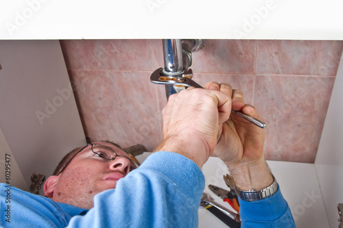 Photo: a plumber repairing a broken sink in bathroom a plumber repairing a broken sink in bathroom
