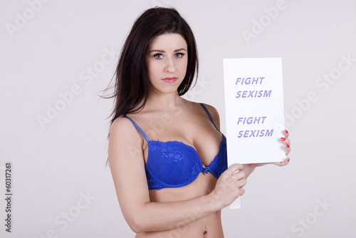 Photo: Portrait of a young woman holding Fight Sexism slogan Portrait of a young woman holding Fight Sexism slogan