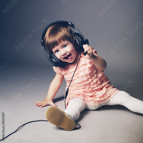 Photo: little happy girl with headphones at home little happy girl with headphones at home