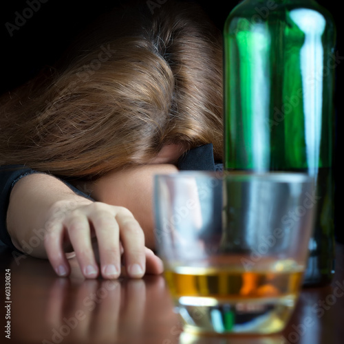Photo: Drunk alcoholic woman sleeping on a table Drunk alcoholic woman sleeping on a table