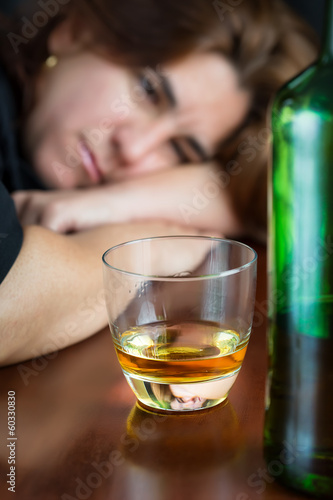 Photo: Drunk woman staring at a glass of whiskey Drunk woman staring at a glass of whiskey