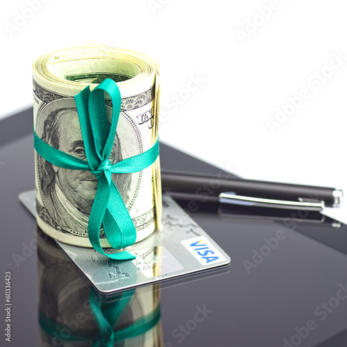 Photo: tablet,tube of dollars,credit card and stylus isolated on white tablet,tube of dollars,credit card and stylus isolated on white