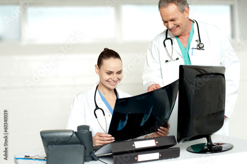 Photo: Physicians reviewing patients x-ray report Physicians reviewing patients x-ray report