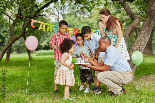 Photo: Father lights candle on birthday cake with lighter Father lights candle on birthday cake with lighter