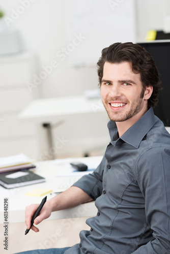 Photo: junger mann am arbeitsplatz im büro junger mann am arbeitsplatz im büro