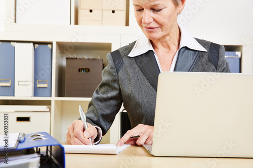 Photo: Geschäftsfrau im Büro macht Notizen Geschäftsfrau im Büro macht Notizen
