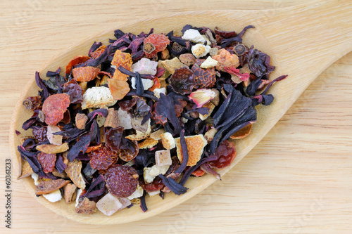 Photo: A spoon of dried Fruit tea on a wooden background A spoon of dried Fruit tea on a wooden background