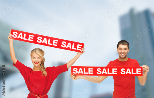 Photo: woman and man with red sale signs woman and man with red sale signs