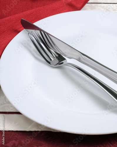 Photo: Knife and fork on a white plate Knife and fork on a white plate