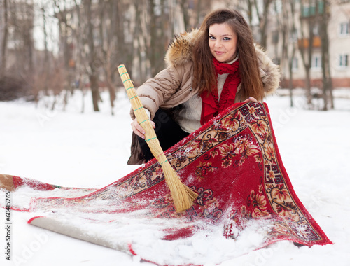 Photo: woman cleans carpet with snow woman cleans carpet with snow