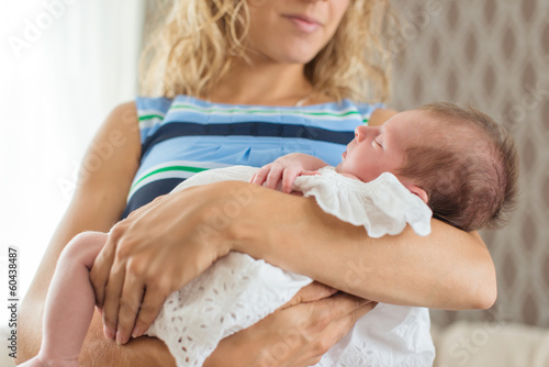 Photo: Newborn in a christening dress sleeping in her mother Newborn in a christening dress sleeping in her mother