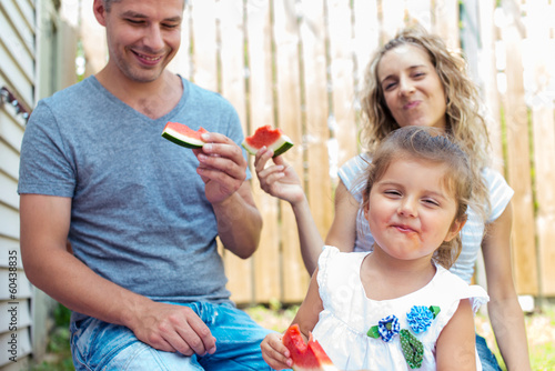 Photo: Parents and little girl having watermelon on a picnic Parents and little girl having watermelon on a picnic