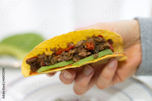 Photo: Close-up of hand holding a taco Close-up of hand holding a taco