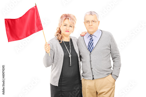Photo: Middle aged couple waving a red flag Middle aged couple waving a red flag