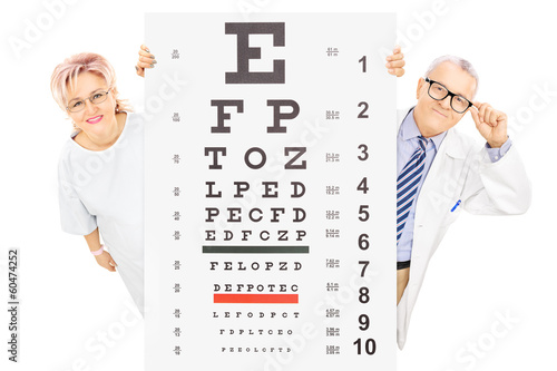 Photo: Middle aged male doctor and female patient standing behind eyesi Middle aged male doctor and female patient standing behind eyesi