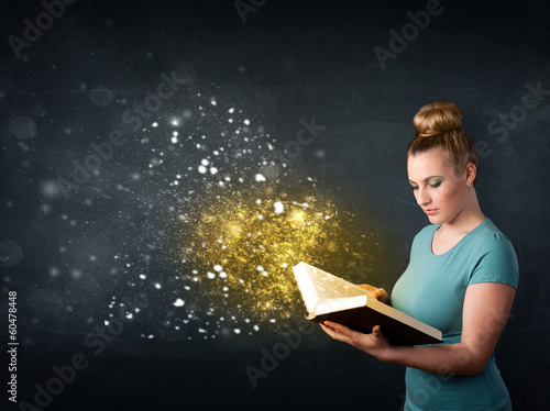 Photo: Young lady reading a magical book Young lady reading a magical book