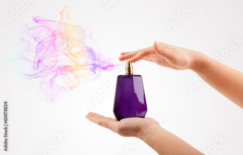 Photo: woman hands spraying perfume woman hands spraying perfume