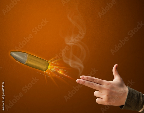 Photo: Gun shaped woman hand with bullet Gun shaped woman hand with bullet