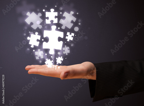 Photo: Puzzle pieces in the hand of a businessman Puzzle pieces in the hand of a businessman
