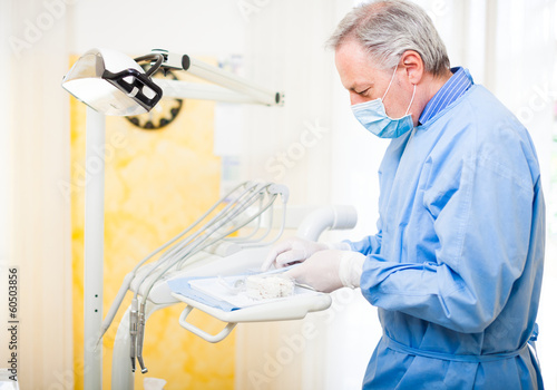 Photo: Portrait of a dentist checking his tools Portrait of a dentist checking his tools