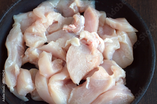 Photo: Sliced chicken diet meat inside old black pan while cooking Sliced chicken diet meat inside old black pan while cooking
