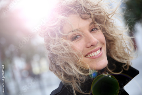 Photo: Smiling attractive woman in town in winter time Smiling attractive woman in town in winter time