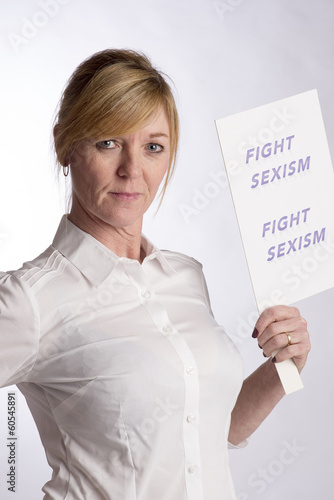 Photo: Mature female protester holding Fight Sexism poster Mature female protester holding Fight Sexism poster