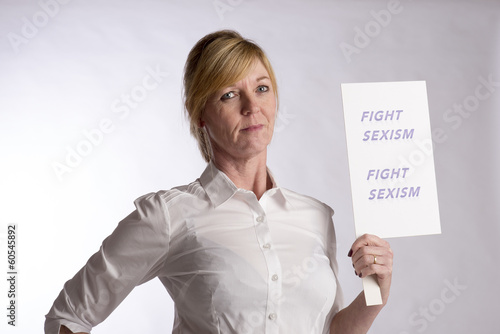 Photo: Mature female protester holding Fight Sexism poster Mature female protester holding Fight Sexism poster