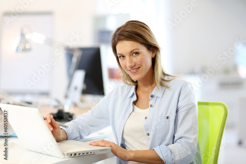 Photo: Smiling businesswoman working in office Smiling businesswoman working in office