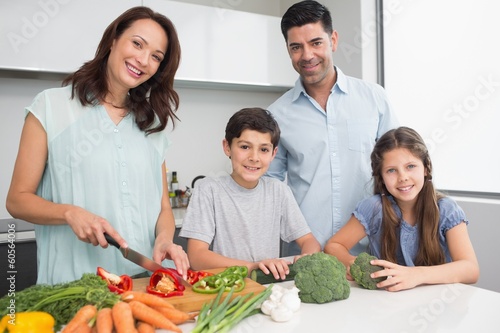Photo: Family chopping vegetables in kitchen Family chopping vegetables in kitchen