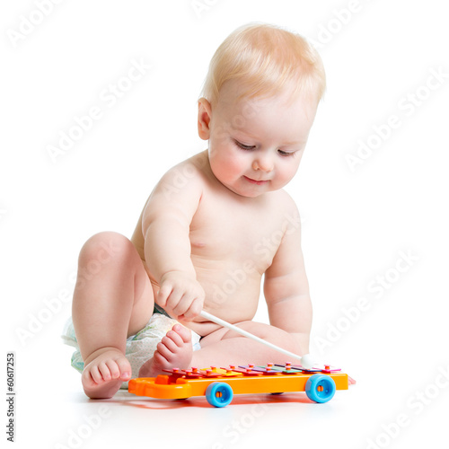 Photo: Funny child playing with musical toys. Isolated on white backgr Funny child playing with musical toys. Isolated on white backgr