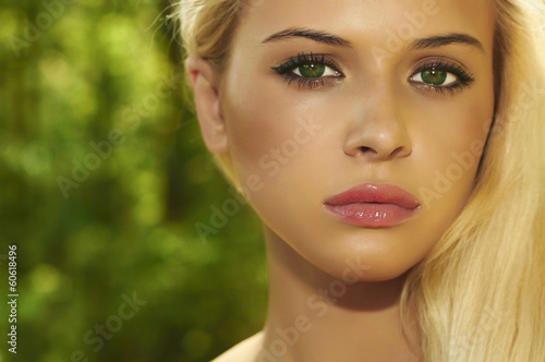 Photo: Beautiful Blond Woman in Forest.Summer Sunlight.Green eyes Beautiful Blond Woman in Forest.Summer Sunlight.Green eyes