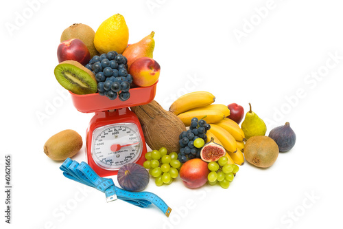 Photo: fruit, measuring tape and kitchen scales close up on white backg fruit, measuring tape and kitchen scales close up on white backg