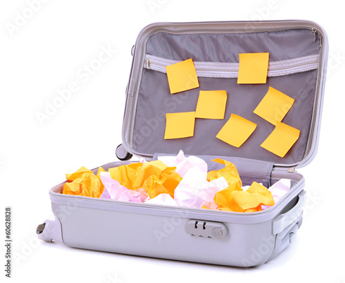 Photo: Open suitcase with paper stickers isolated on white Open suitcase with paper stickers isolated on white