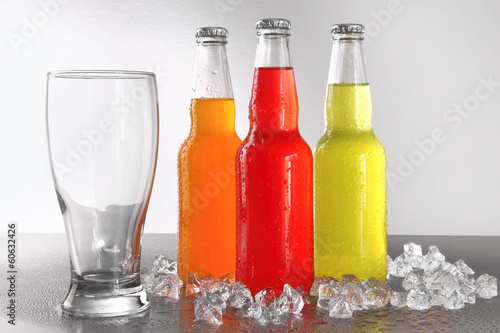 Photo: Three bottles with drinks with glass and ice Three bottles with drinks with glass and ice