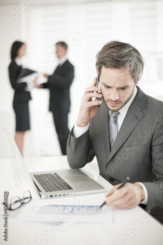 Photo: Businessman at phone in meeting Businessman at phone in meeting