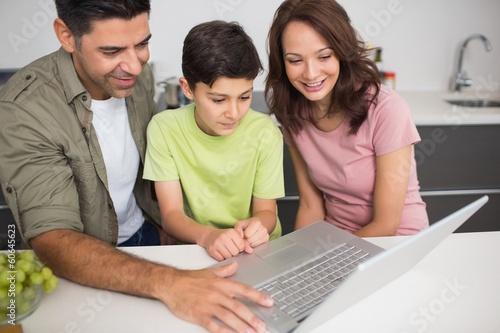 Photo: Smiling couple with son using laptop Smiling couple with son using laptop
