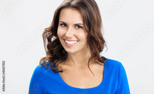 Photo: Happy smiling young woman, over grey Happy smiling young woman, over grey